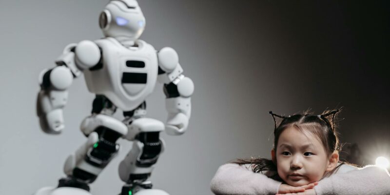 a girl looking at the white toy robot