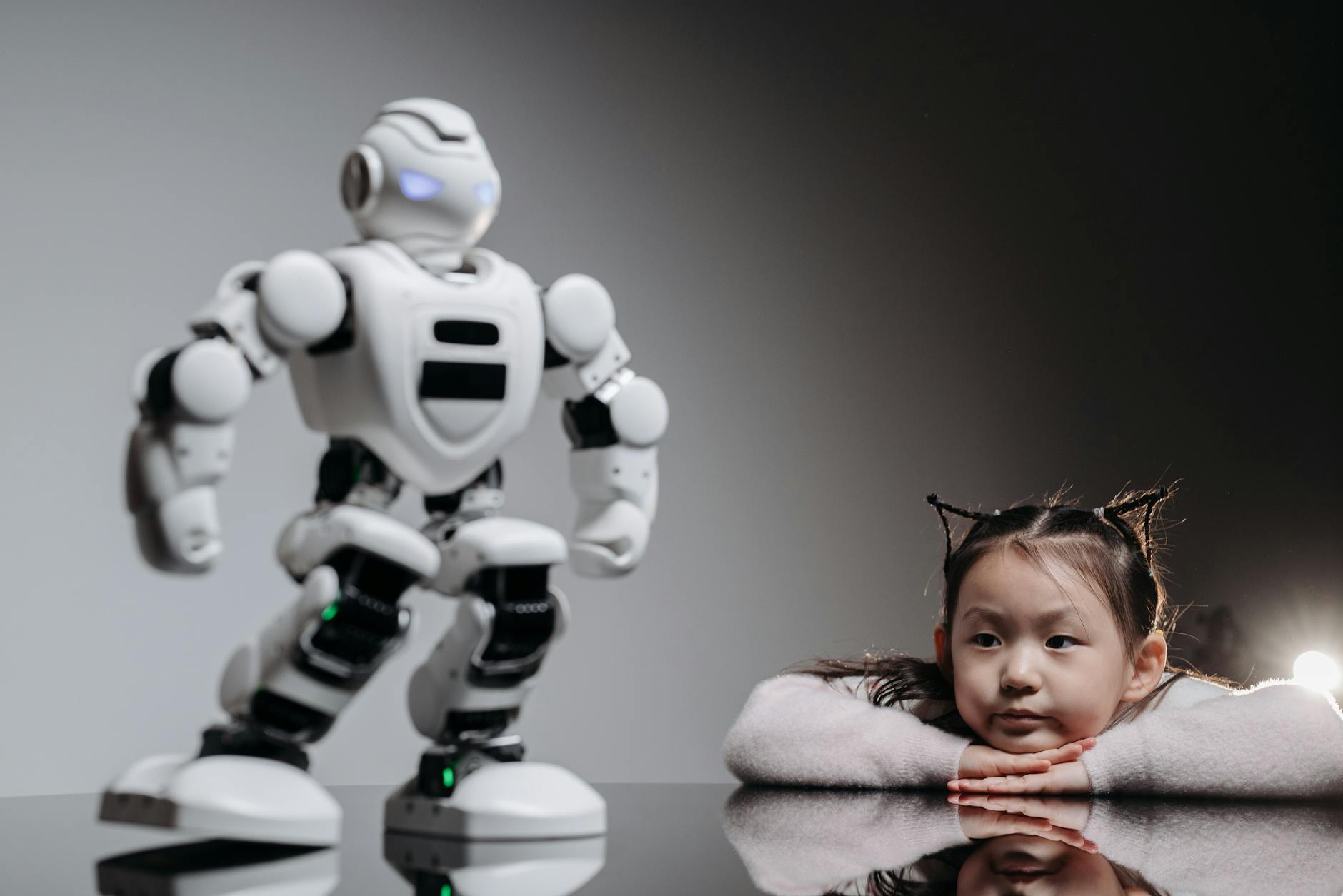 a girl looking at the white toy robot